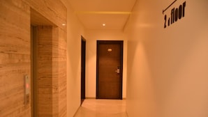 Um corredor com parede de madeira e uma porta com a inscrição '2º andar'.