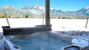 A hot tub with a view of snow-covered mountains.