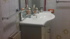 A bathroom with a white sink, mirror, and a towel rack. - Ghirla lake. Studio flat (Ghirla)