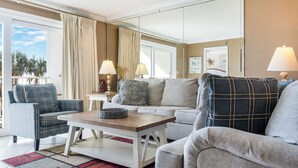 Een zithoek met een bank, fauteuils, een salontafel en twee lampen.