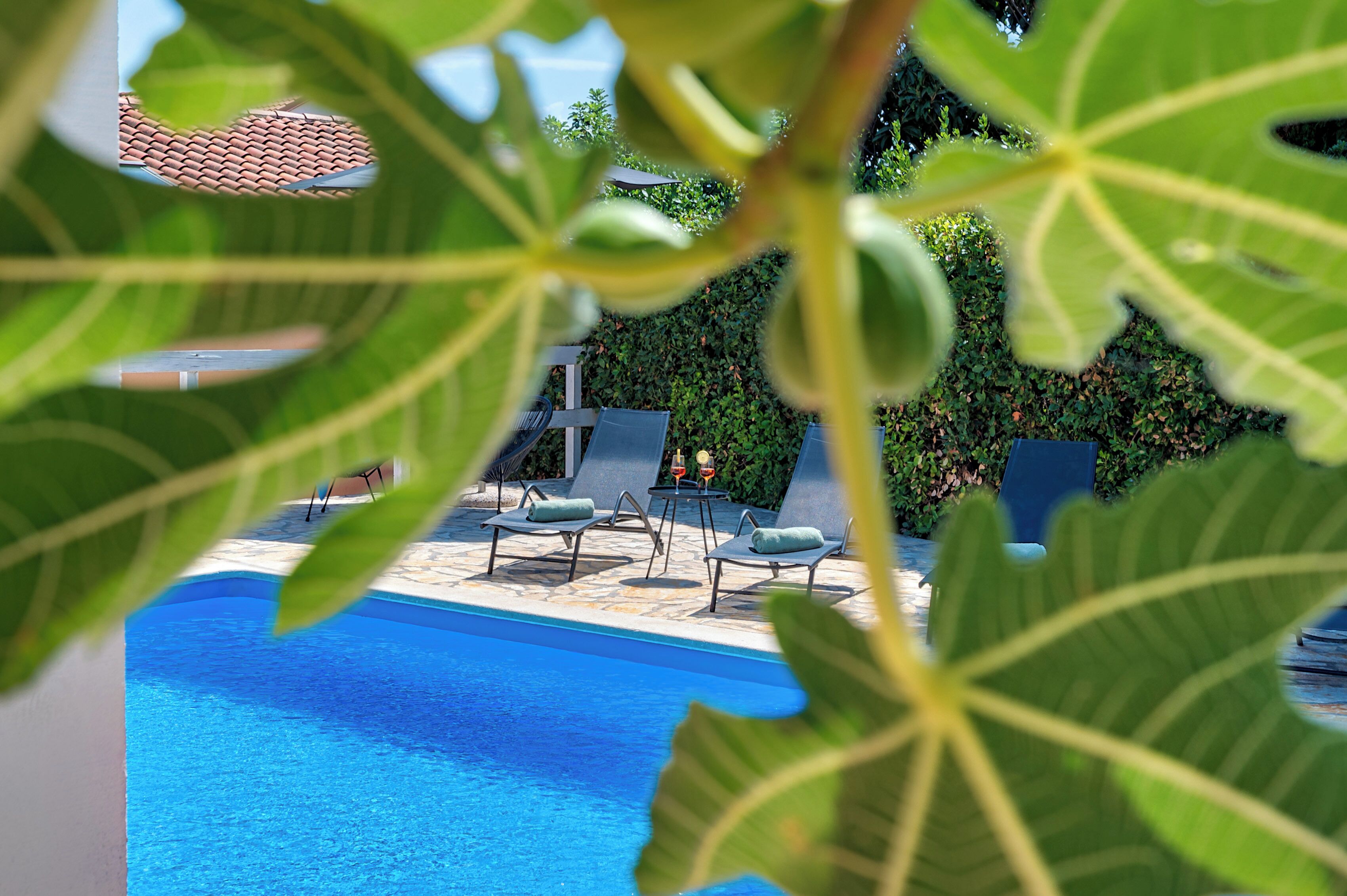 A pool area with lounge chairs and a stone deck.