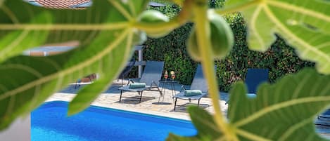 A pool area with lounge chairs and a stone deck.