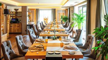 Un espace repas comprenant une longue table en bois, plusieurs chaises et une variété d’articles de décoration de table.