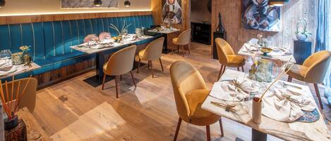 A restaurant with wooden flooring, blue cushioned seating, and modern decor.