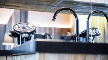 Una cocina moderna con un grifo de acero inoxidable, una cafetera y una encimera de madera.