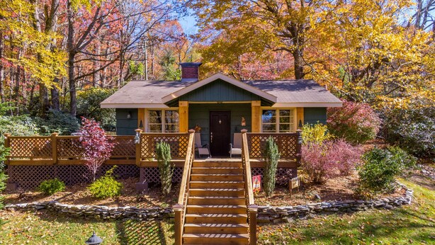 A rustic cabin with a wooden staircase leading to a front door, surrounded by autumn foliage. - Bear Bungalow - 1 mile from Main Street Blowing Rock! Hot Tub - Pet Friendly - Fenced In Yard (Blowing Rock)