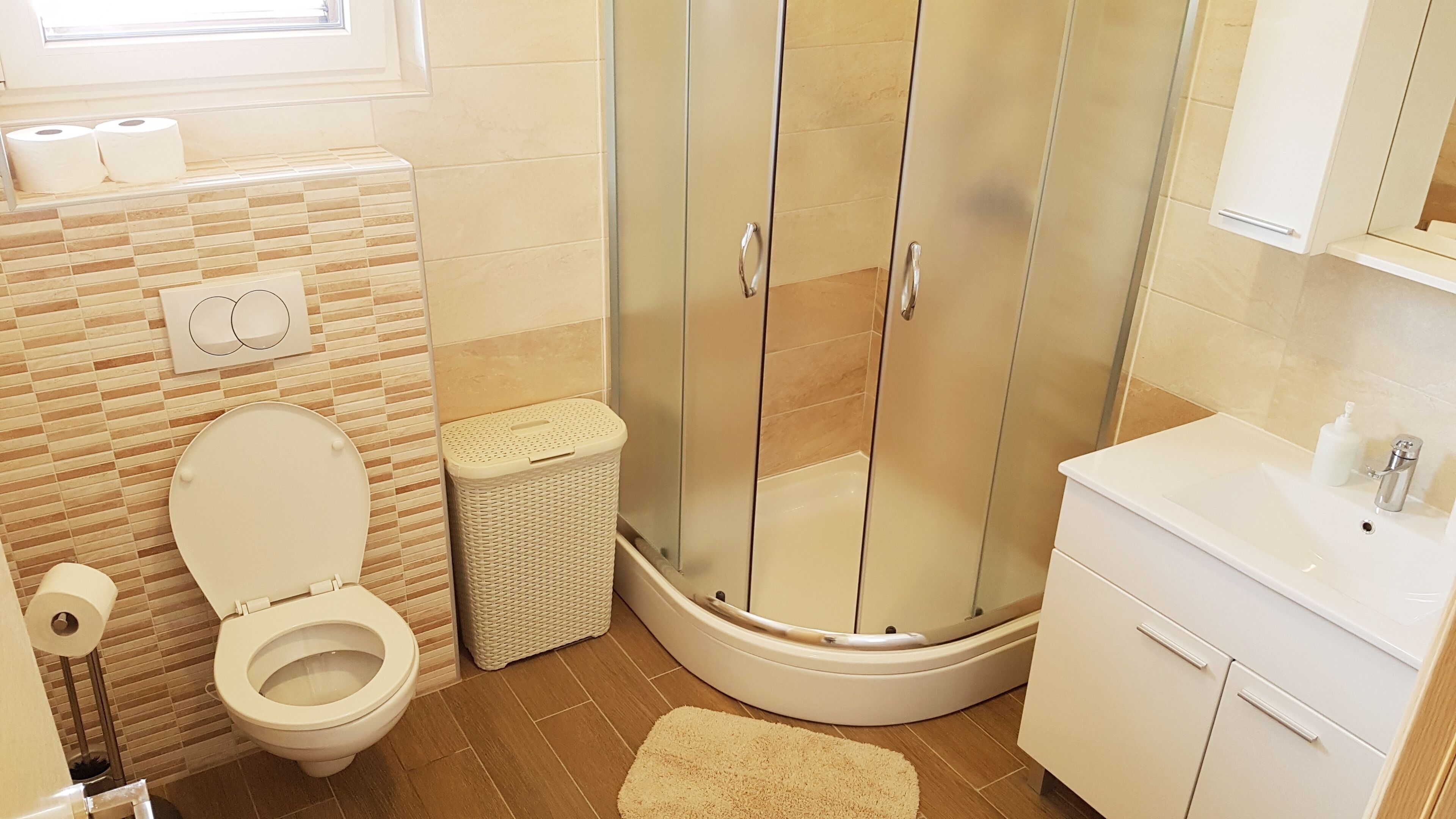 Un baño moderno con inodoro, ducha y lavamanos.