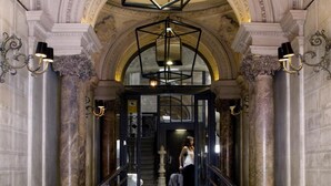 Un vaste hall d’entrée orné de colonnes de marbre, doté d’un sol à carreaux et d’un escalier menant à l’étage supérieur.