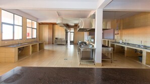 Een ruime keuken met meerdere werkplekken, grote ramen en een centraal ventilatiesysteem.