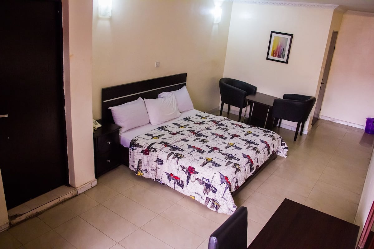 Un dormitorio con cama, escritorio y silla.