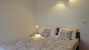A neatly made bed with a quilt, two pillows, and a bedside lamp.