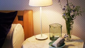 A neatly arranged bedside table with a lamp, a vase with flowers, and a glass container. - Experience nature, peace and quiet and Astrid Lindgren's world - Welcome to Småland (Mariannelund)