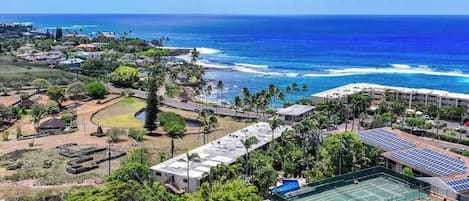 Ett hotell vid kusten med en tennisbana, en pool och utsikt över havet.