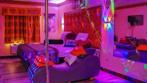 A modern bedroom with a bed, a sofa, and a mirror. - Luxe Inn and Suites (Dolton)