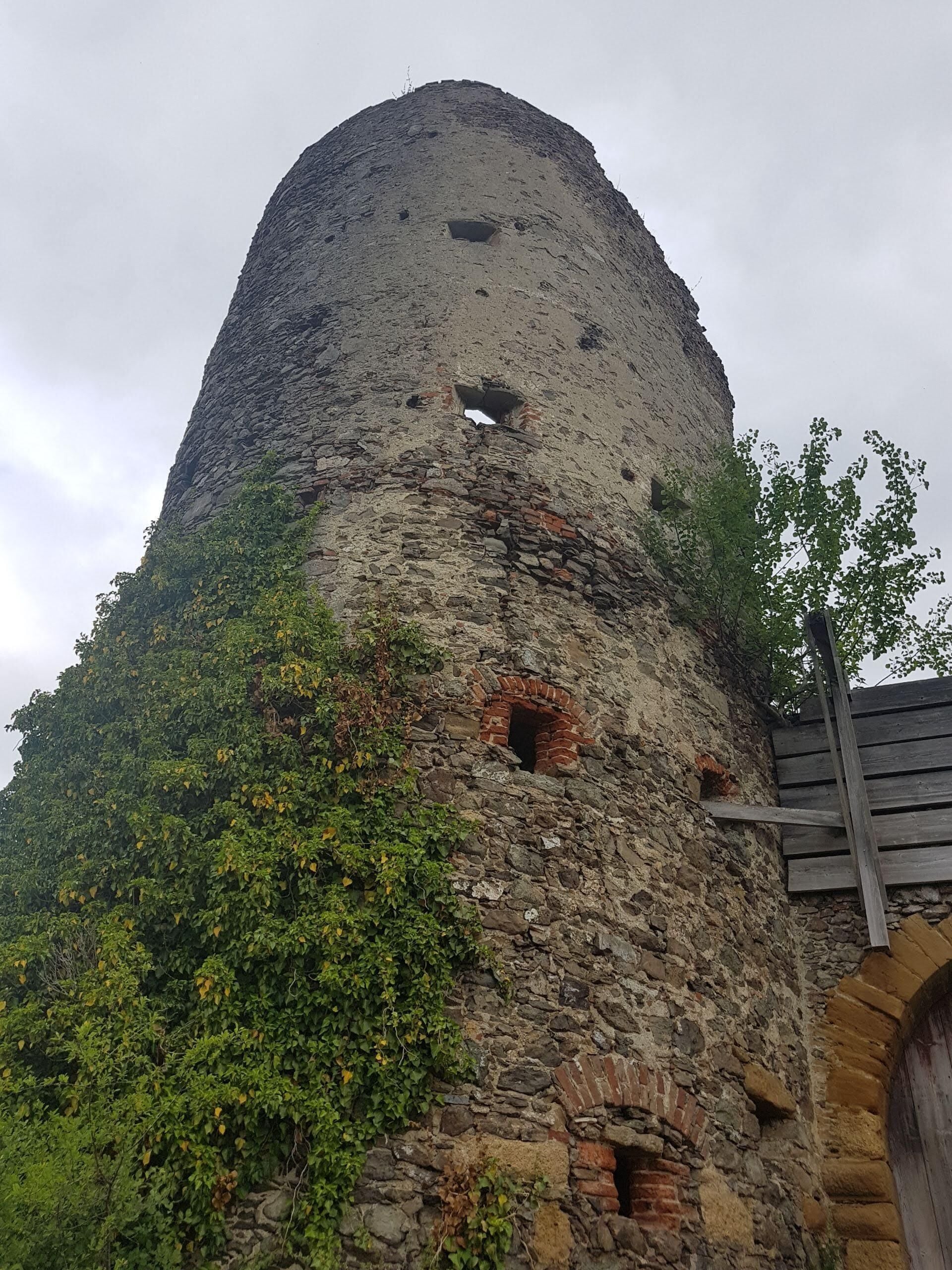 A stone tower with multiple openings and a wooden staircase.