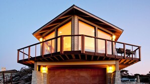 Une maison moderne dotée d’un garage, d’un balcon et de grandes fenêtres.