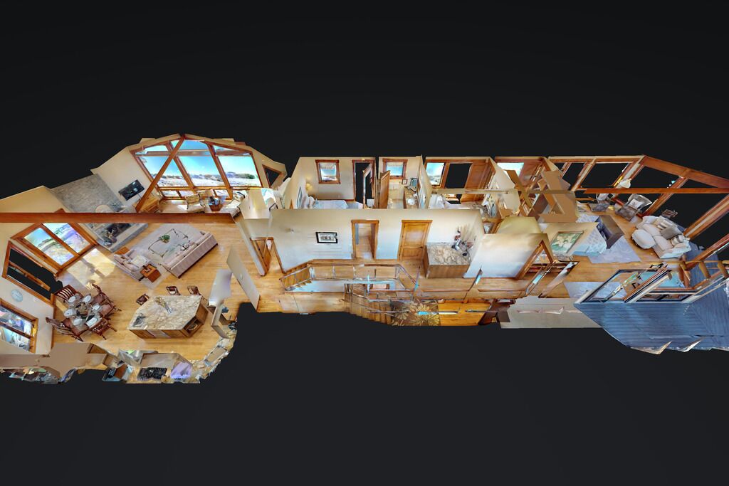 A spacious, modern hotel interior with multiple rooms, large windows, and a central area with seating and a fireplace.