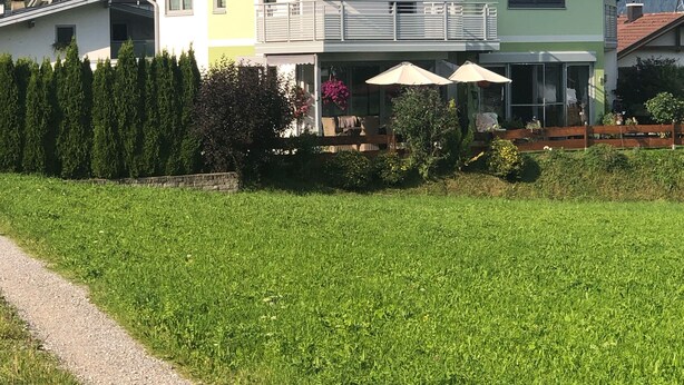 Een twee verdiepingen tellend huis met zonnepanelen, een balkon en uitzicht op bergen.