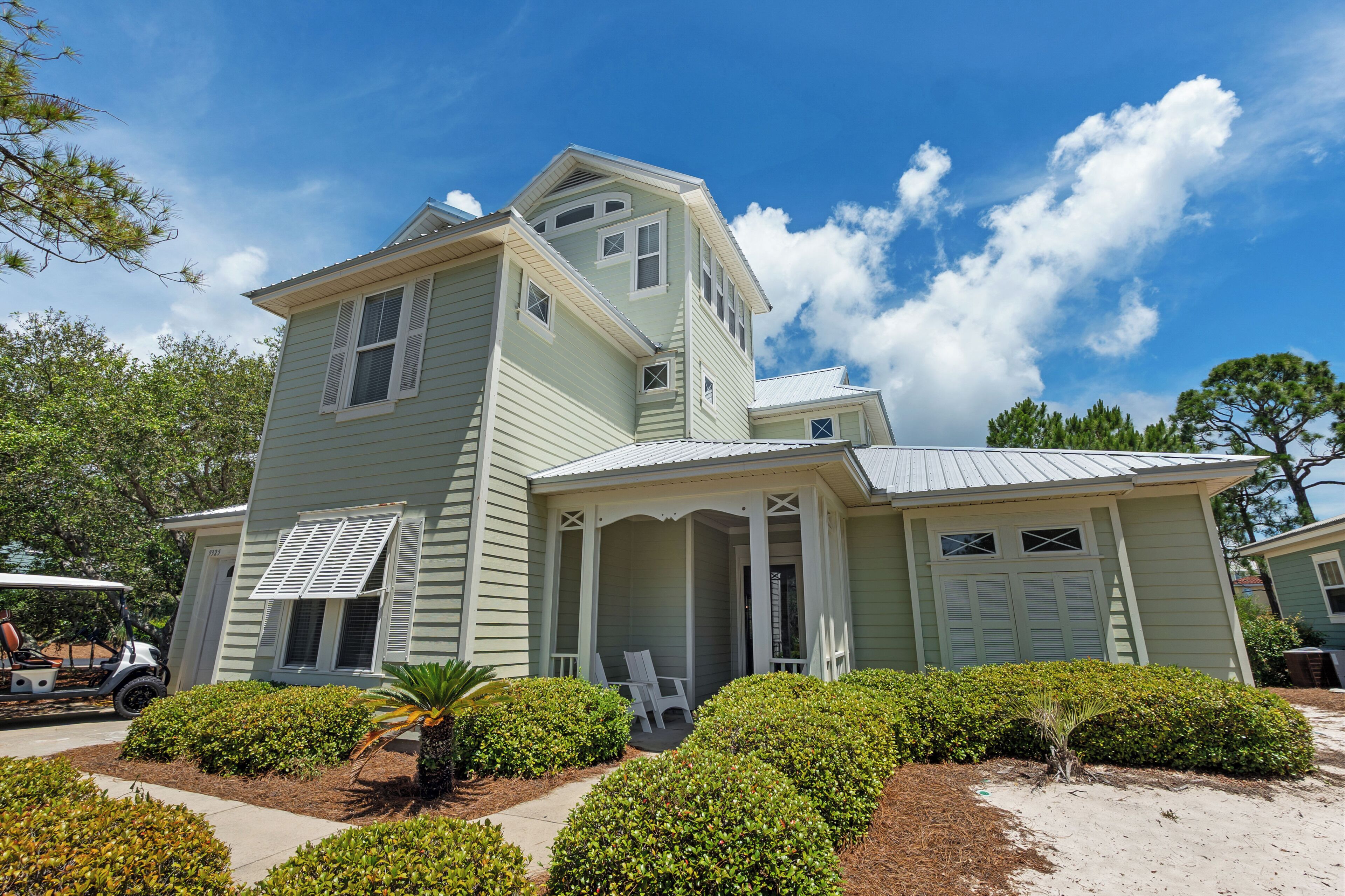 A two-story house with a porch, a garage, and a golf cart parked outside.
