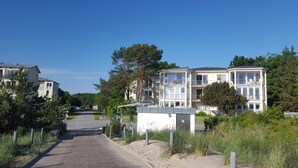Un quartier résidentiel composé d’immeubles à plusieurs étages, d’un chemin pavé et entouré de verdure.