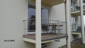 Un immeuble résidentiel à plusieurs étages, doté de balcons, avec une date inscrite (02.12.2018) et une fenêtre visible.