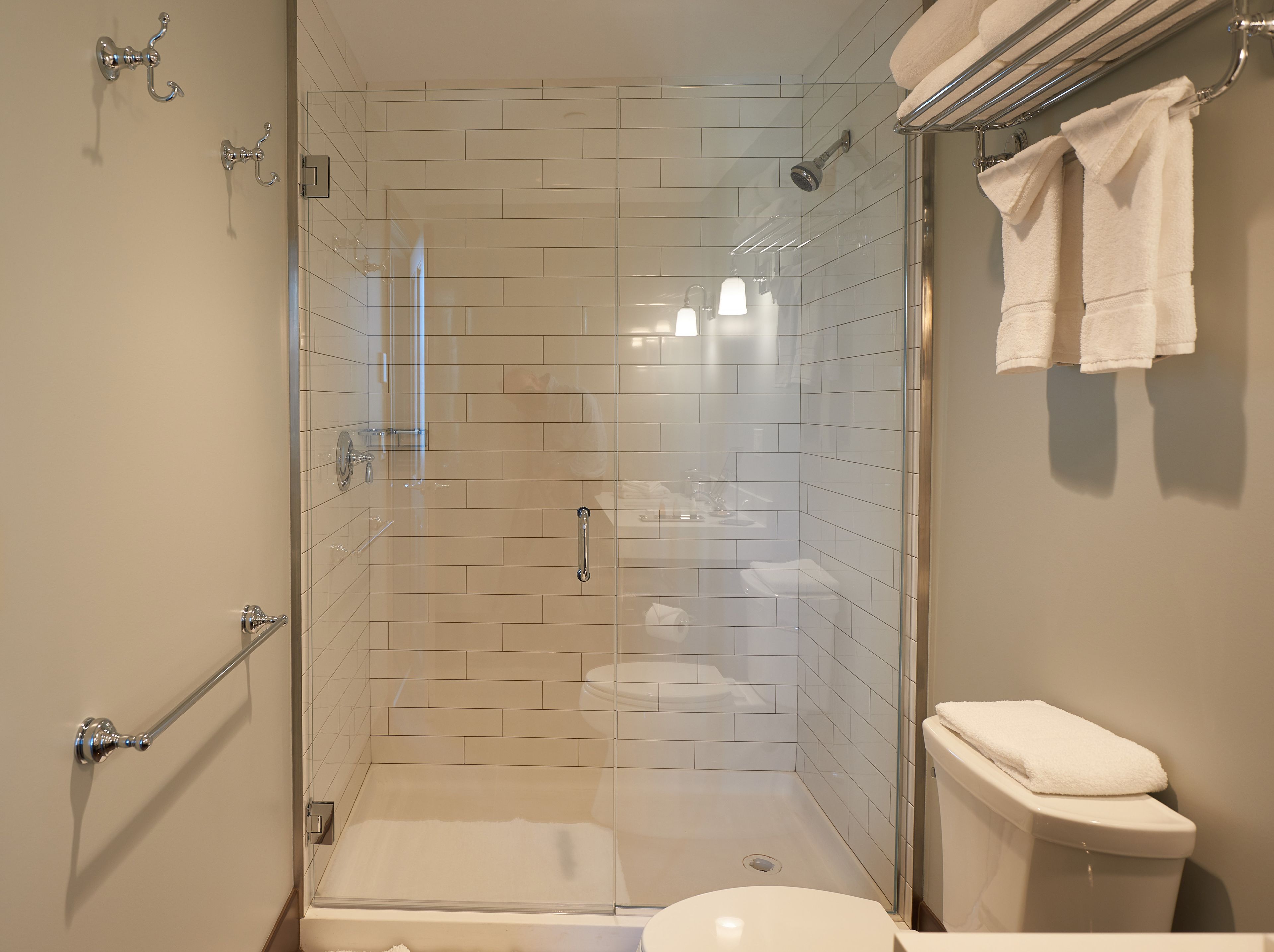A modern bathroom with a glass-enclosed shower, a glass-enclosed toilet, and a glass-enclosed bathtub.