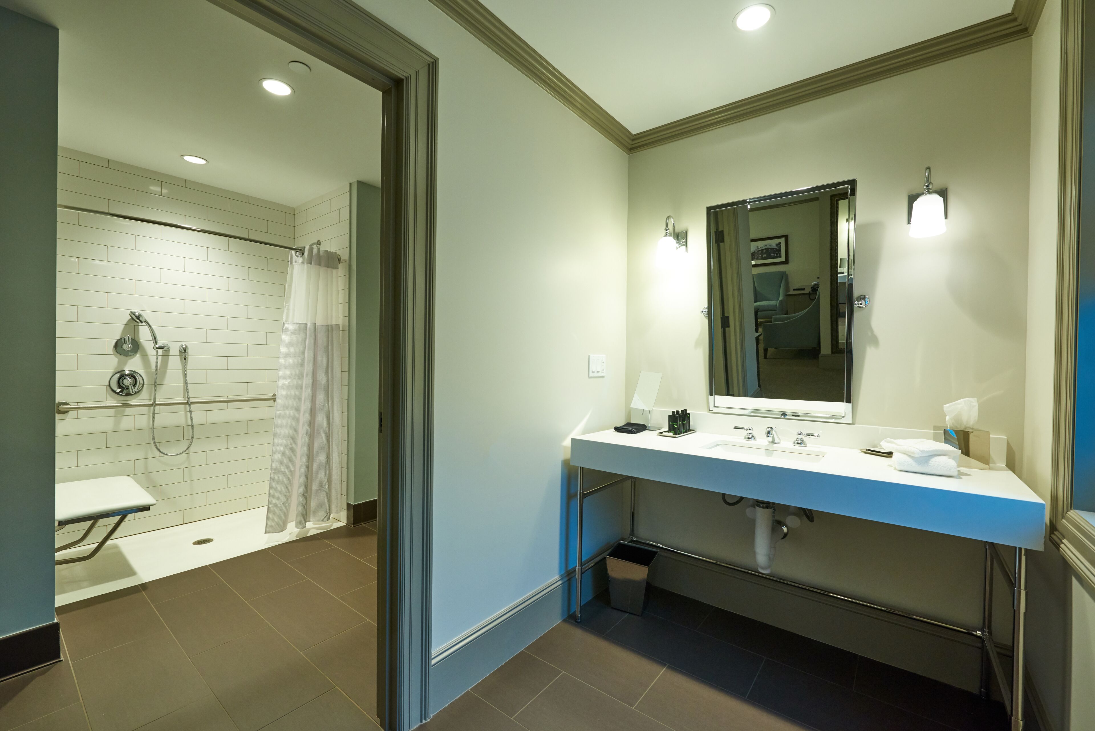 Een moderne badkamer met douche, toilet en wastafel.