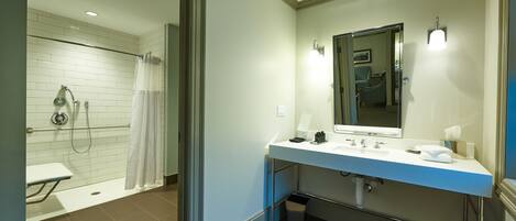 Een moderne badkamer met douche, toilet en wastafel.