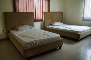 Two single beds with headboards, a window with curtains, and a tiled floor. - David Royal Suites (Lagos)