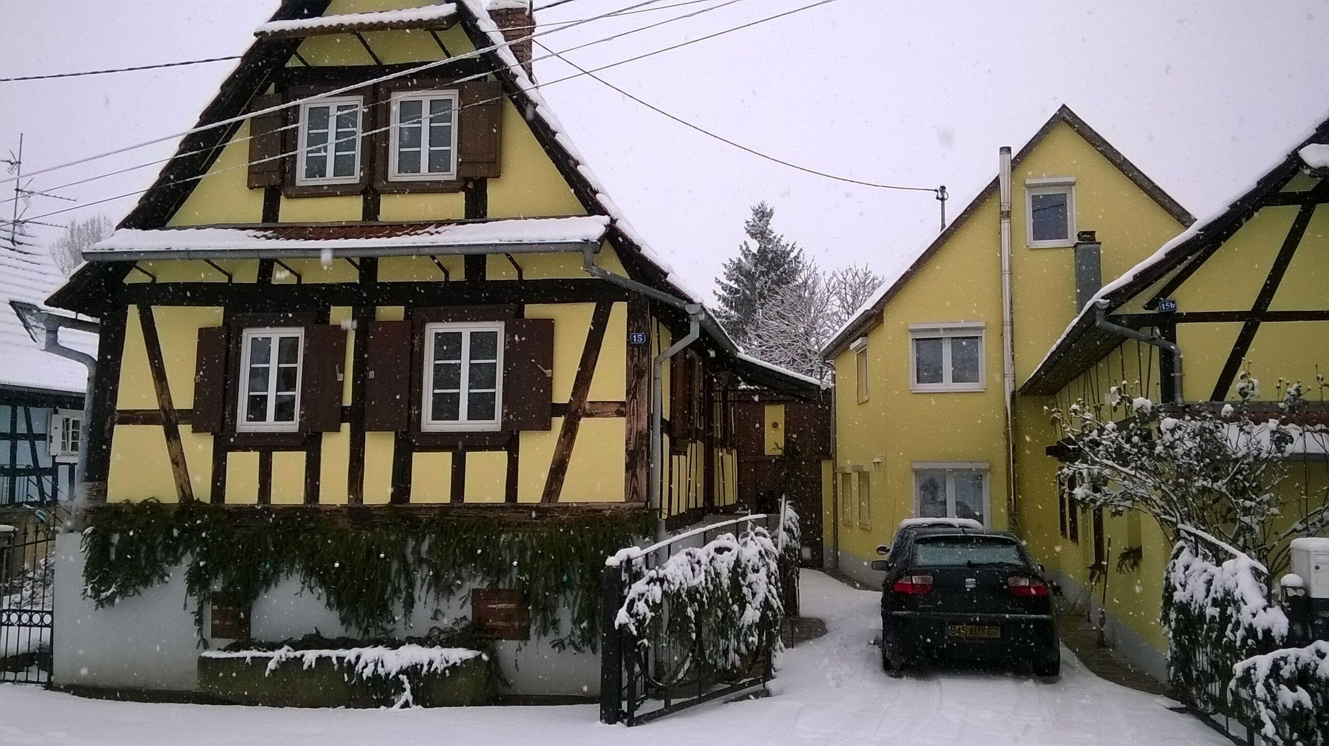 A traditional half-timbered house with a car parked in front.