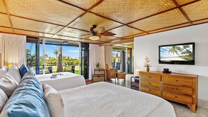 A spacious bedroom with a large bed, a wooden dresser, a television, and a view of the outdoors. - Kaanapali Golf course front, Beach cabana, Jacuzzi (Kaanapali)