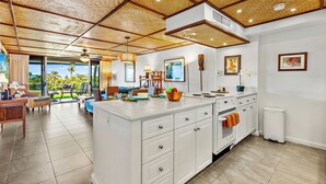 A modern kitchen with a large island, white cabinetry, and a view to the outdoors. - Kaanapali Golf course front, Beach cabana, Jacuzzi (Kaanapali)