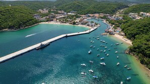 Un pueblo costero con un puerto deportivo, barcos y un muelle.