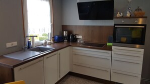 Een moderne keuken met een spoelbak, aanrecht, kastjes, een koffiezetapparaat, een broodrooster en een oven.