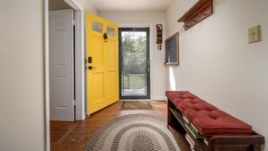 A hallway with a yellow door, a red bench, and a patterned rug. - Large home in Broadkill.  Just a block to the beach! 907 N Bayshore (Milton)