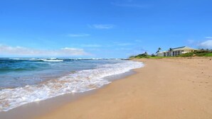 A beach with a house on the right.
