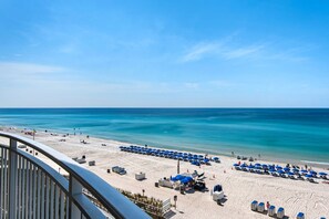 A beach with rows of blue umbrellas, a sandy beach, and a clear blue sky. - 0507 - Fresh and Fun Coastal Condo (Panama City Beach)
