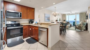 Una cocina moderna con electrodomésticos de acero inoxidable, armarios de madera y un comedor con vistas.