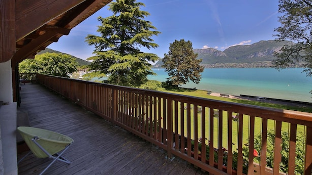 Eine Holzterrasse mit Blick auf einen See und Berge.