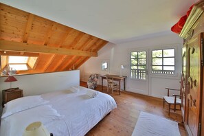 A bedroom with a wooden ceiling, a bed, a desk, and a wardrobe.