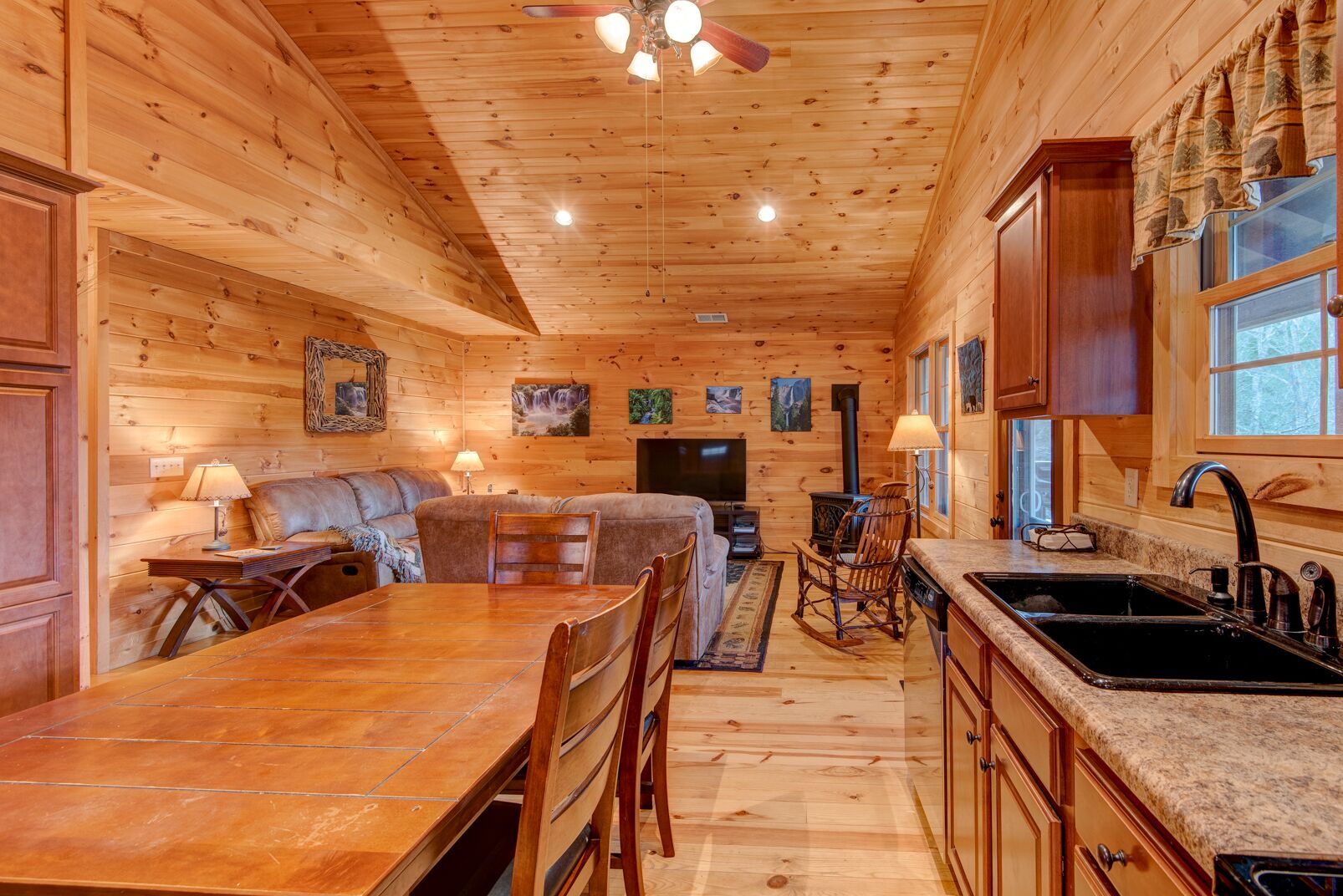 A cozy cabin interior with a dining area, kitchen, and living space.
