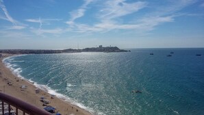 A beach with a clear view of the sea, a distant castle-like structure, and several boats. - Sonoran Sky 502 Absolute Beach Paradise Haven Oceanfront Condo (Puerto Penasco)