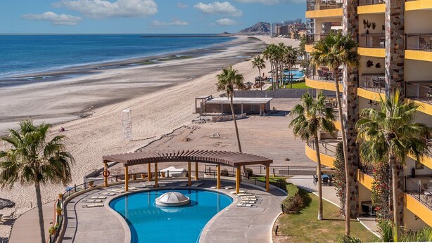 A resort with a swimming pool, beach view, and a multi-story building with balconies. - Sonoran Sky 502 Absolute Beach Paradise Haven Oceanfront Condo (Puerto Penasco)
