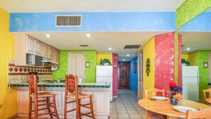Una cocina con comedor, que incluye microondas, refrigerador y una mesa de comedor con sillas.