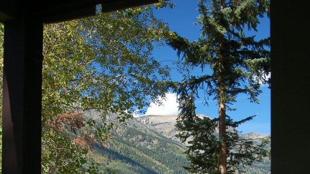 A view from a covered area with a mountain landscape in the background. - Nestle into the peace and quiet of the Aspens (Wilson)