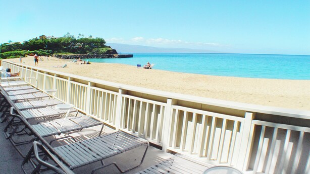 A beach with lounge chairs and a railing, overlooking the ocean. - Top Floor Studio Ocean View, Golf Cart, Beach Cabana, Jacuzzi, Pool (Kaanapali)