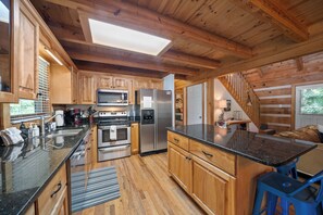 Una cocina moderna con armarios de madera, electrodomésticos de acero inoxidable y una isla grande.
