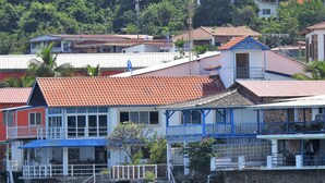 A coastal building with a red-tiled roof, a balcony, and a staircase leading to a higher level. - Agua Sol Villa (Taboga)