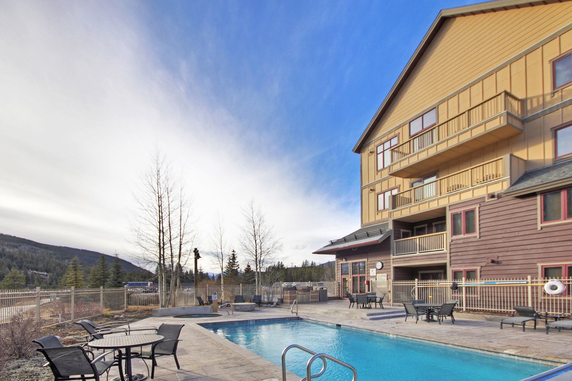 Un hotel con piscina, zona de estar al aire libre y vistas a montañas.