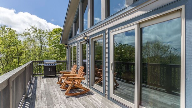Una terrazza riparata con posti a sedere all'aperto e un barbecue.